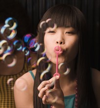 Asian woman blowing bubbles