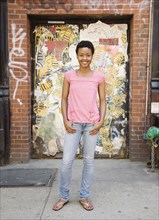 African woman standing near urban doorway