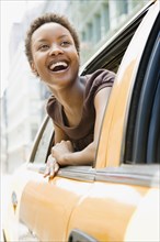 African woman looking out taxi window in wonder