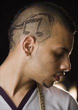 Hispanic teenage boy with musical notes shaved into his head