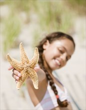 Hispanic girl holding starfish