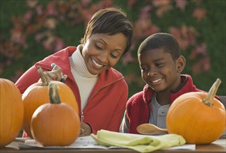 African mother and son carving pumpkins