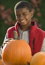 African boy holding pumpkin