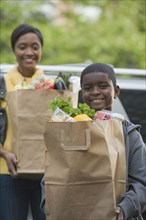 African boy helping mother unload groceries