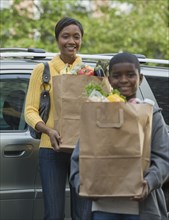 African boy helping mother unload groceries