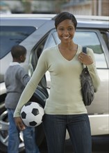 African mother holding soccer ball