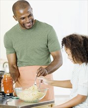 African father and daughter preparing pasta