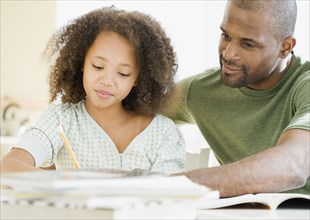 African father helping daughter with homework
