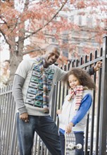 African father and daughter near fence