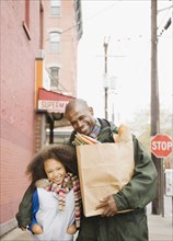 African father and daughter with groceries