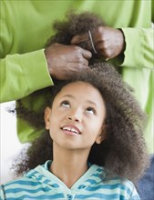 African father styling daughter's hair