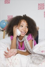 African girl using telephone on bed