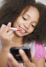 African girl applying lipstick