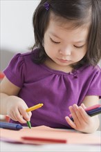 Toddler girl coloring with crayons