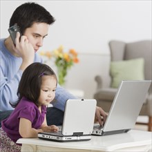 Father and daughter using laptops
