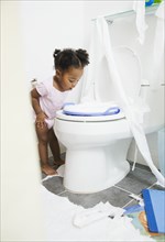 African American girl looking into toilet