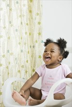 African American girl laughing in chair