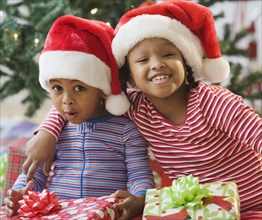 African American brother and sister holding Christmas gifts