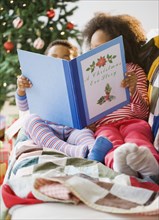 African American brother and sister reading Christmas book