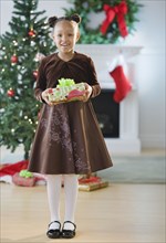 African American girl in dress holding Christmas gift