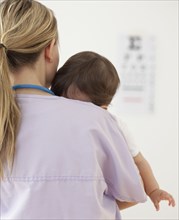 Nurse holding mixed race baby girl