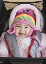 Mixed race baby girl bundled up in winter coat