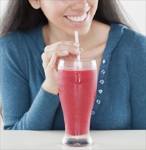 Hispanic woman drinking fruit smoothie