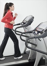 Hispanic woman walking on treadmill