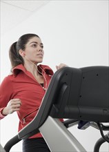 Hispanic woman walking on treadmill