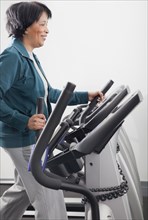 African woman using treadmill in health club