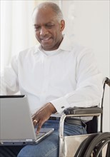 African man in wheelchair using laptop