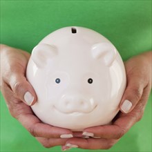 Close up of African woman holding piggy bank