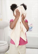 African girl drying face with towel