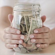 Woman holding jar with money