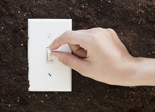 Woman flipping light switch in soil