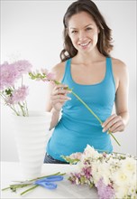 Mixed race woman arranging flowers