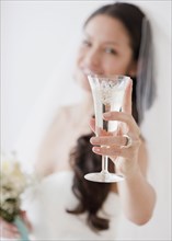 Mixed race bride holding champagne flute