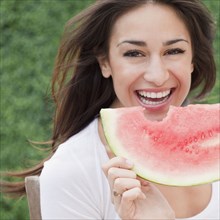 Hispanic woman eating watermelon
