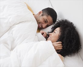 Couple laying in bed and smiling
