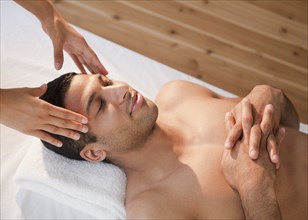 Mixed race man receiving head massage