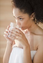 Mixed race woman drinking water