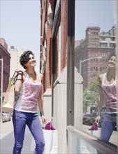 Mixed race woman window shopping on urban street