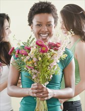 African woman holding bouquet of flowers