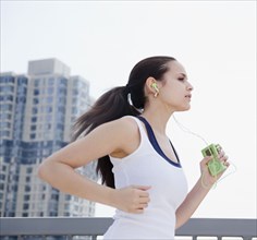 Mixed race woman jogging with mp3 player