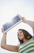 Mixed race woman holding solar panel