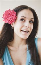 Mixed race woman with flower in hear