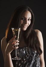 Mixed race woman drinking champagne