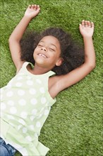Mixed race girl laying in grass