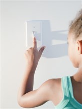Mixed race girl turning off light
