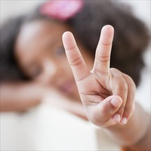 Mixed race girl making the peace symbol